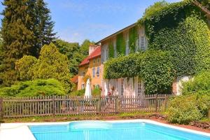 una casa con una valla y una piscina frente a ella en Moulin de chez Joyeux, en Thiat