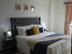 um quarto com uma cama grande com almofadas amarelas e azuis em Lindo DPTO en Condominio Cama KING em Santa Cruz de la Sierra