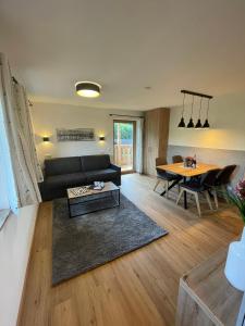 - un salon avec un canapé noir et une table dans l'établissement Obermühlhof, à Saalfelden