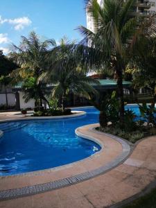 a swimming pool with palm trees in a resort at Lindo DPTO en Condominio Cama KING in Santa Cruz de la Sierra