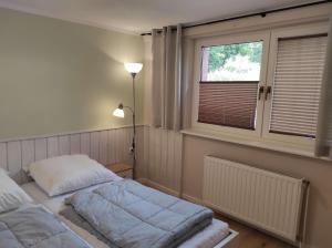 un dormitorio con una cama y una ventana en Gästehaus Harzklause 1, en Sieber