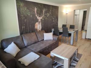 Sala de estar con sofá y ciervo en la pared en Gästehaus Harzklause 1, en Sieber 8 fotos más