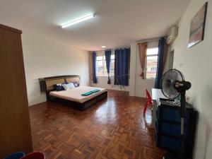 a bedroom with a bed and a fan in a room at Leng Leng Homestay in Sibu