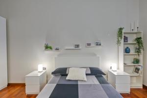 ein weißes Schlafzimmer mit einem Bett und zwei weißen Nachttischen in der Unterkunft Vico 4 Rooms in Turin
