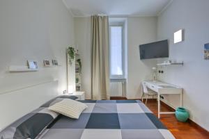 Schlafzimmer mit einem Bett, einem Schreibtisch und einem TV in der Unterkunft Vico 4 Rooms in Turin