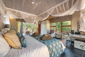una camera da letto con un grande letto con cuscini sopra di Kusudalweni Safari Lodge & Spa a Guernsey Nature Reserve