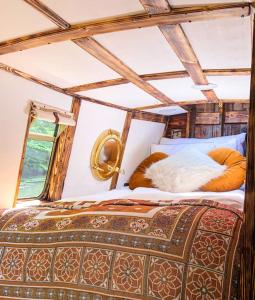 a bed with two pillows on top of it at SNUG 30ft NARROWBOAT WITH FIREPLACE in Bishopbriggs