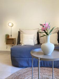 - un salon avec un canapé bleu et un vase sur une table dans l'établissement Studio Le Provençal proche plage, à Saint-Mandrier-sur-Mer