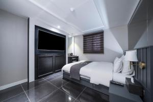 a bedroom with a large bed and a television at Hotel Duruwa Main Building in Incheon