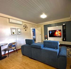a living room with a blue couch and a tv at Exquisite short and long stay in Gaborone