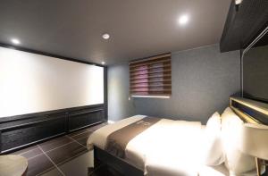 a bedroom with a large bed and a window at Hotel Duruwa Main Building in Incheon