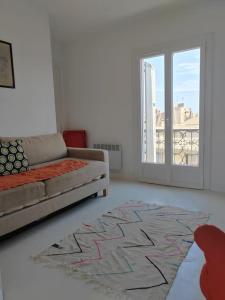 un soggiorno con divano e una grande finestra di Superbe T3 terrasse avec vue Centre historique a Montpellier