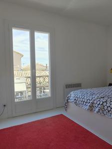una camera con un letto e una grande finestra di Superbe T3 terrasse avec vue Centre historique a Montpellier
