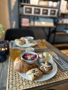 einen Tisch mit Platten aus Brot und Gebäck in der Unterkunft Bed & Breakfast 'Le Faucon' in Valkenburg