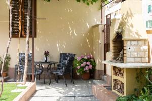 d'une terrasse avec une table, des chaises et un four en briques. dans l'établissement Antique Garden Villa, à Split
