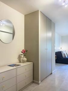 - un salon avec une commode et un miroir dans l'établissement Studio Le Provençal proche plage, à Saint-Mandrier-sur-Mer