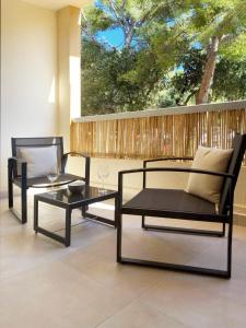 - une terrasse avec 2 chaises et une table basse dans l'établissement Studio Le Provençal proche plage, à Saint-Mandrier-sur-Mer