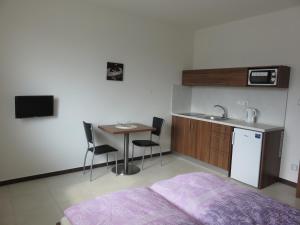 a bedroom with a bed and a table and a sink at Penzion U Dulíka in Veselí nad Moravou