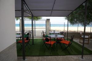 un gruppo di tavoli e sedie con vista sulla spiaggia di Aria di sale B&B a Marina di Strongoli