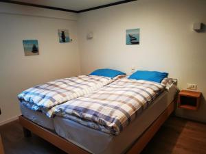 Schlafzimmer mit einem Bett mit blauer und weißer Bettwäsche in der Unterkunft Steinbock in Grächen