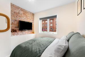 a bedroom with a bed and a brick wall at Demims Apartments Oslo -- Cozy, Central & Stylish in Oslo