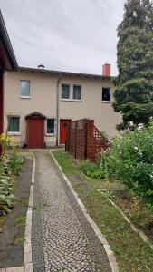 a house with a red door and a brick driveway at Ferienwohnung Paul Hille in Dresden