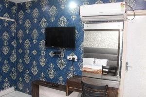 una camera con una scrivania e una TV di Hotel O Food Plaza a Zirakpur Altre 10 foto