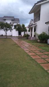 un patio frente a una casa blanca en Tulips Misty hights 2BHK villa, en Yelagiri