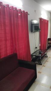 sala de estar con cortinas rojas y sofá en Tulips Misty hights 2BHK villa, en Yelagiri