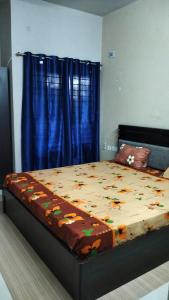 a bedroom with a large bed with a blue curtain at Tulips Misty hights 2BHK villa in Yelagiri