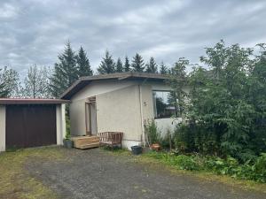 ein kleines Haus mit einer Bank davor in der Unterkunft Art Guesthouse Olla in Selfoss