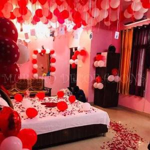 een kamer met een bed met rode en witte ballonnen bij OYO Hotel Mongoose Palace in Narela