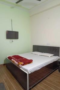 een slaapkamer met een groot bed met een witte matras bij OYO Hotel Mongoose Palace in Narela