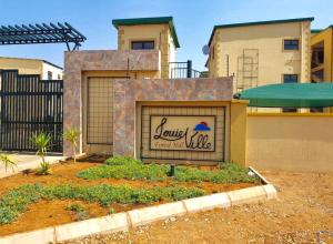 a building with a sign in front of a house at Exquisite short and long stay in Gaborone