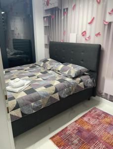 um quarto com uma cama com um edredão e um espelho em Capital33 em Sarajevo