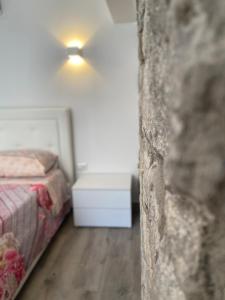 um quarto com uma cama e uma luz na parede em La Perla Del Borgo em Montefalcone di Val Fortore