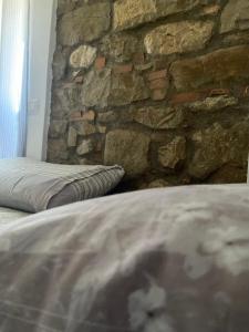 Cama en habitación con pared de piedra en La Perla Del Borgo en Montefalcone di Val Fortore
