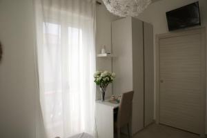 una stanza con finestra e tavolo con vaso di fiori di Aria di sale B&B a Marina di Strongoli