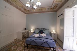 a bedroom with a blue bed with a coffered ceiling at Regina Stella in Lascari