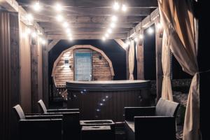 Cette chambre dispose d'un bar avec des chaises et des lumières. dans l'établissement VILLAGE RESORT Sauna & Jacuzzi & Netflix, à Tworkowa