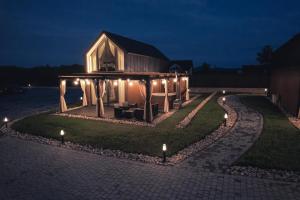 a house with lights on the lawn at night at VILLAGE RESORT Sauna & Jacuzzi & Netflix in Tworkowa