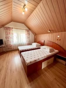 sypialnia z 2 łóżkami na poddaszu w obiekcie Pensiunea Stoian w mieście Cristian