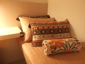 - un lit avec 4 oreillers et une étagère dans l'établissement The Shore Artsy Studio Kota Kinabalu, à Kota Kinabalu