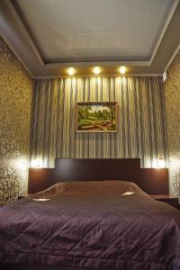 マグニトゴルスクにあるRusskaya Usadbaの大きなベッド付きのベッドルーム1室、壁に絵画が飾られています。