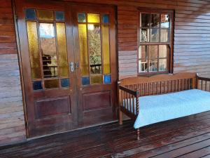 Mystic Mountain Cottage في كلارينس: شرفة مع سرير وأبواب