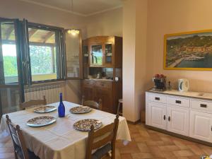 B&B Terre Toscane في Ciggiano: غرفة طعام مع طاولة ومطبخ