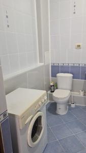 a bathroom with a washing machine and a toilet at Колливинг на Республике (золотой квадрат) in Astana