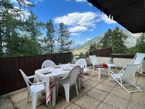 a table and chairs on a patio with a view at Appartement Les Orres, 2 pièces, 8 personnes - FR-1-322-191 in Les Orres