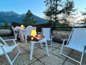 a patio with white chairs and a table with a view of mountains at Appartement Les Orres, 2 pièces, 8 personnes - FR-1-322-191 in Les Orres