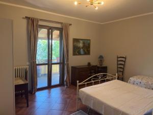 B&B Terre Toscane في Ciggiano: غرفة نوم بسرير وباب زجاجي منزلق